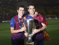 Barcelona's David Villa (L) and Cesc Fabregas pose with the trophy after they beat Porto in their European Super Cup soccer match at Louis II stadium in Monaco August 26, 2011. [Xinhua/Reuters Photo]